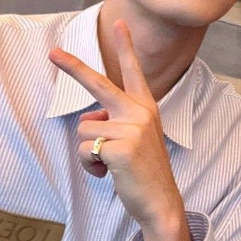 a young man making the v sign with his finger while sitting in front of him