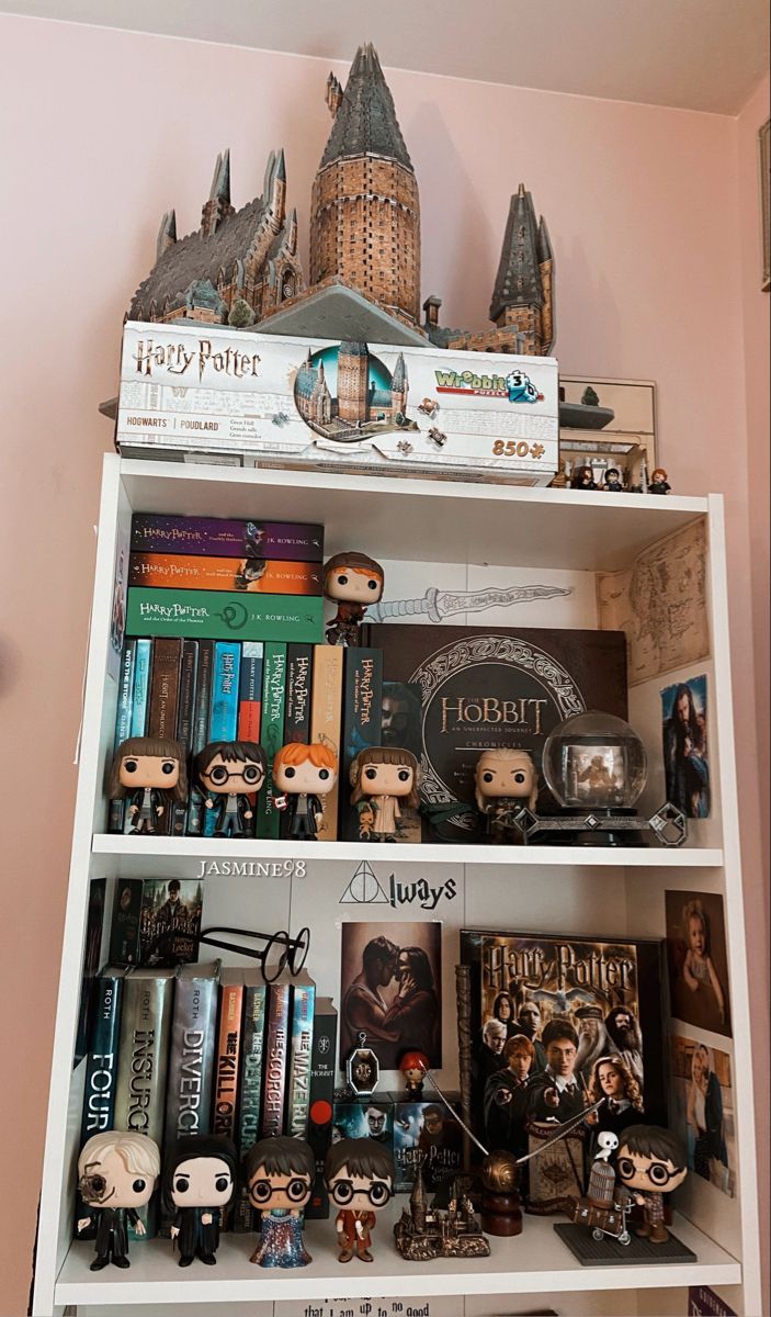 a book shelf filled with harry potter books and figurines on top of it