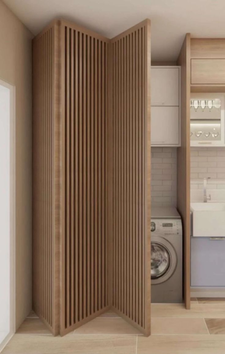 an open door to a washer and dryer in a room with wood paneling