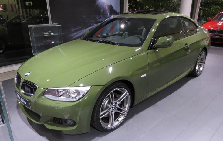 a green car is on display in a showroom