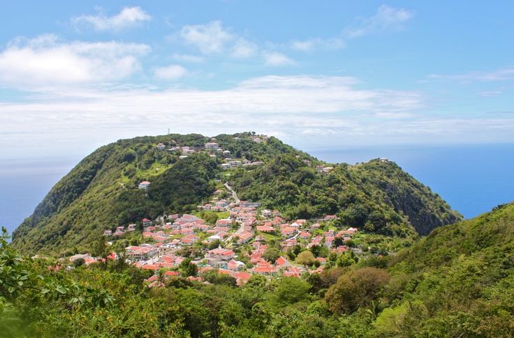 a small town nestled on top of a mountain in the middle of the ocean and surrounded by greenery