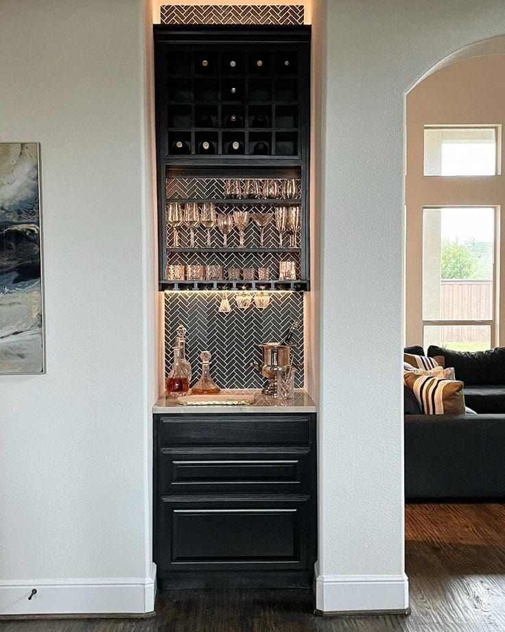 a living room filled with furniture next to a wall mounted wine rack in front of a couch