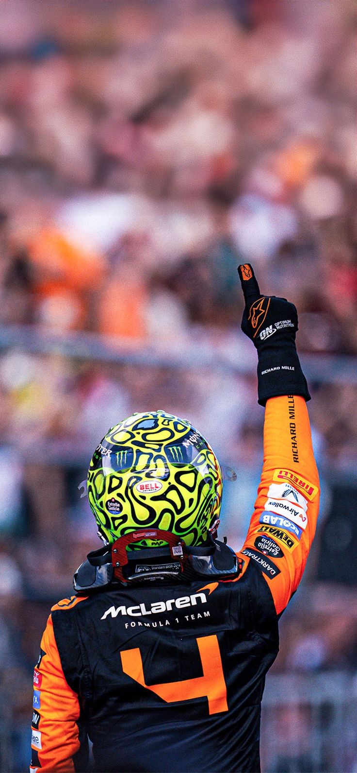 a man in an orange and black uniform raising his fist up to the crowd at a sporting event