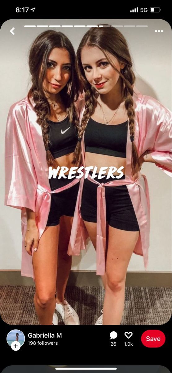 two girls in matching outfits posing for the camera with their arms around each other, both wearing pink jackets and black shorts