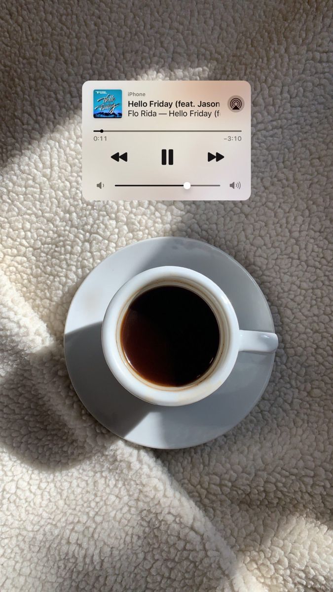 a cup of coffee sitting on top of a saucer next to an mp3 player