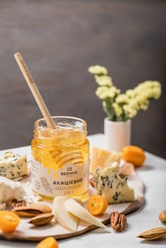 a jar of honey surrounded by cheese and nuts