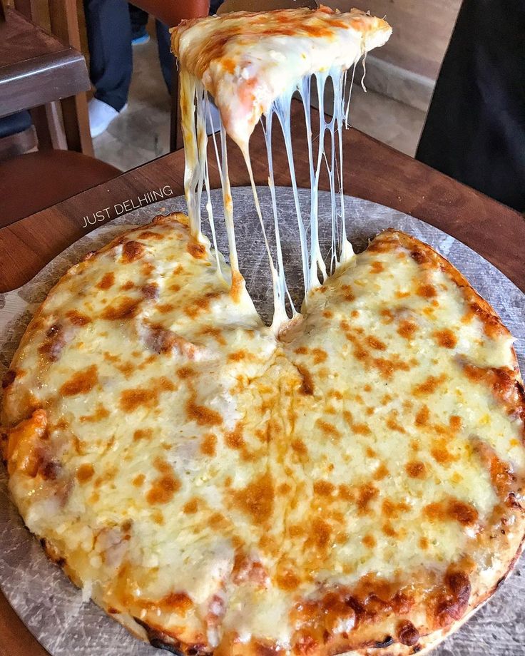 a cheese pizza being lifted with a spatula