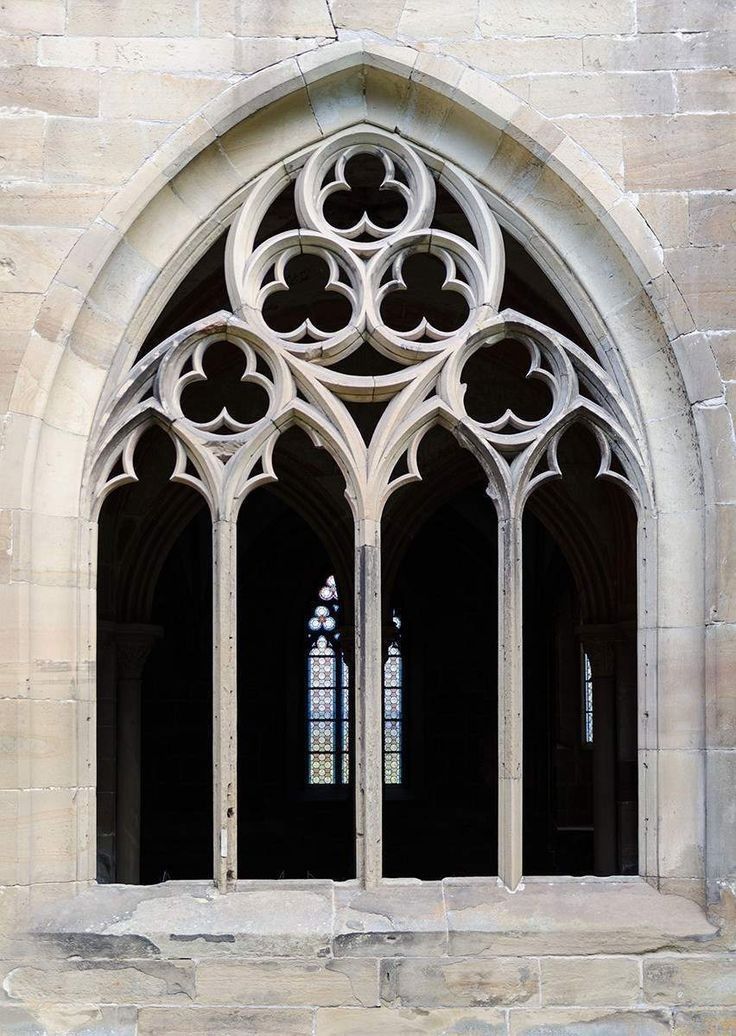 an arched window in the side of a stone building