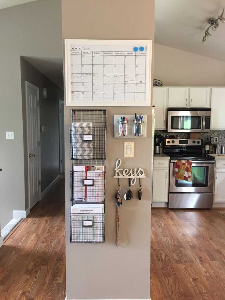 a kitchen with a refrigerator, stove and wall calendars on the door frame that says keep organized