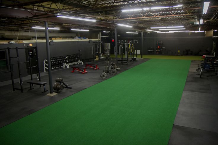 an indoor gym with green carpet and equipment