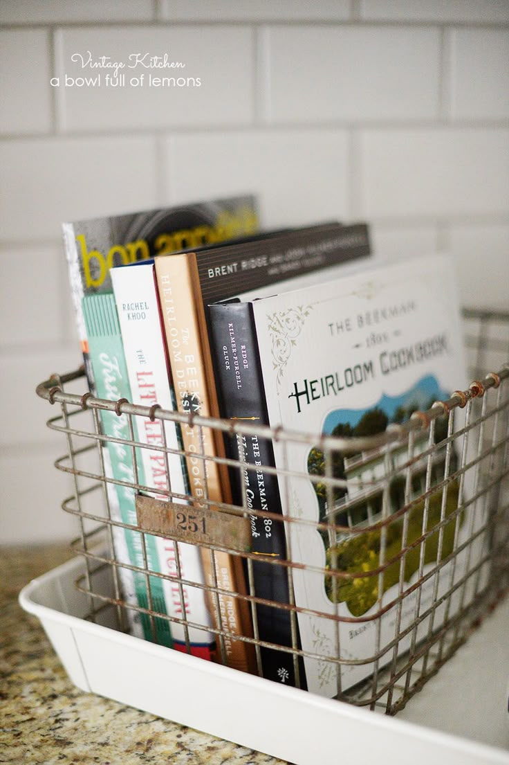 a metal basket filled with books on top of a counter