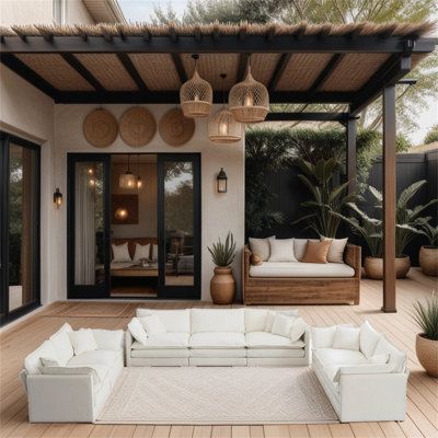 a white couch sitting on top of a wooden floor under a pergolated roof