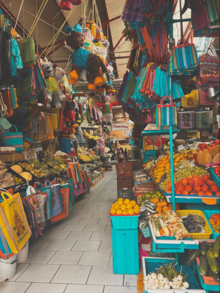 an outdoor market with lots of fruits and vegetables on the shelves, including oranges