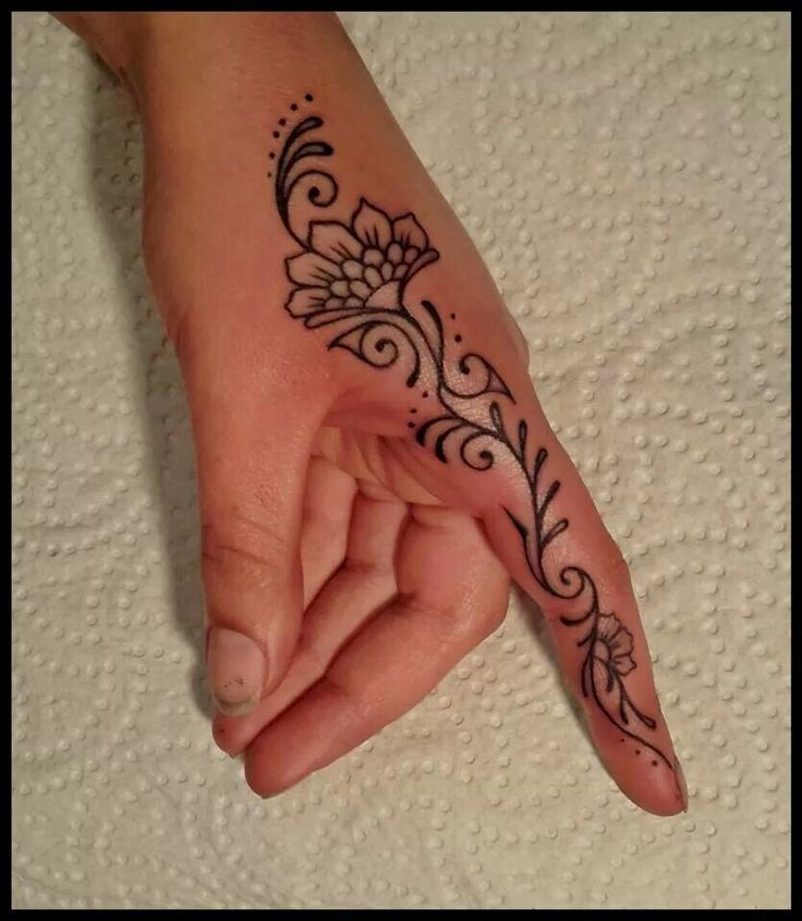 a woman's hand with a flower tattoo on it