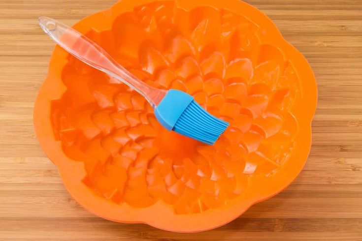 an orange plastic bowl with a toothbrush in it