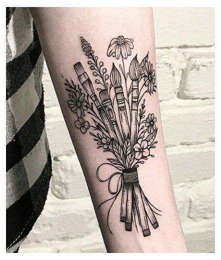 a woman's arm with flowers and arrows on it