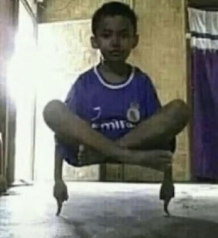 a young boy sitting on the floor with his legs crossed