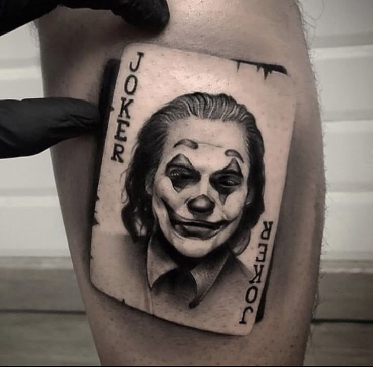 a man's leg with a joker face on it and the words joker written in black ink