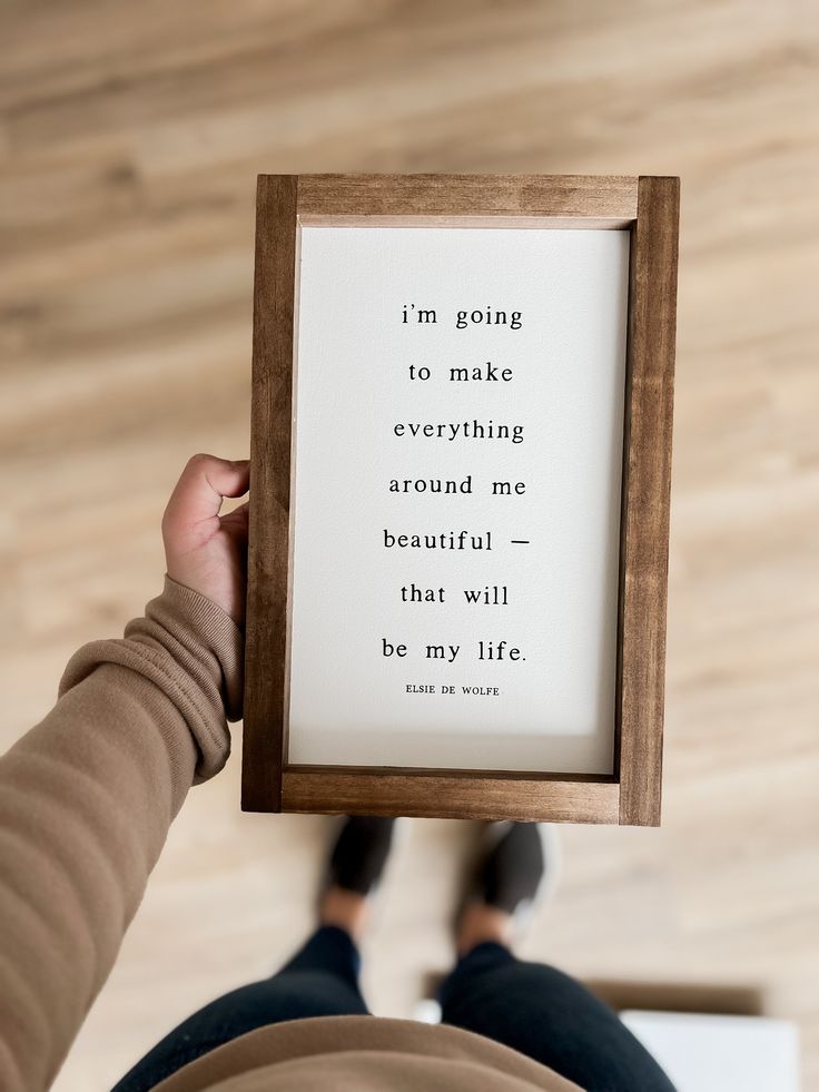 a person holding up a framed quote in front of their face with the words i'm going to make everything around me beautiful that will be my life