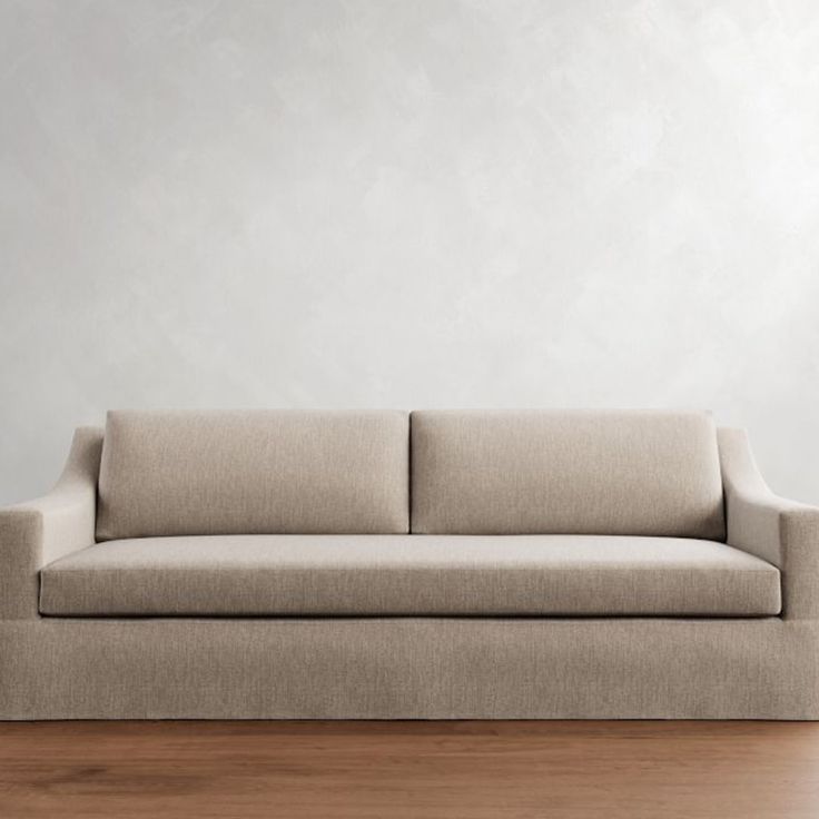 a couch sitting on top of a hard wood floor next to a white wall in an empty room