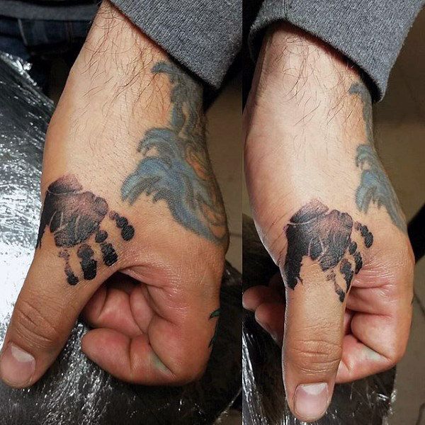 two hands with tattoos on them holding something in one hand and another showing the other