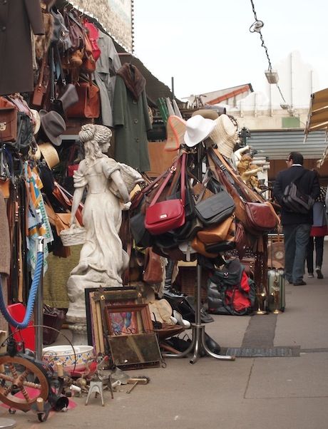 there are many bags and purses on display at this street vendor's stall