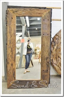 a woman standing in front of a wooden frame