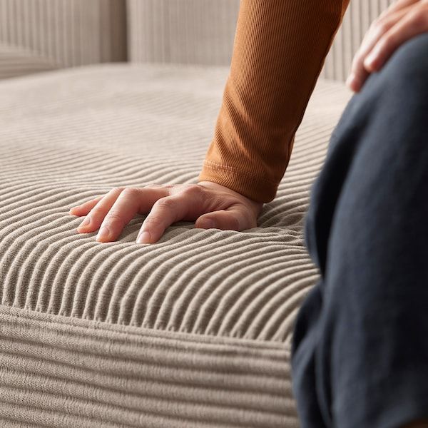 a person sitting on top of a bed with their foot resting on the mattress cover