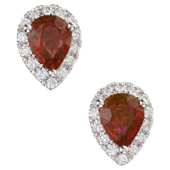 Ruby and diamond earrings. 2 well cut pear shaped rich red rubies mounted in 14k white gold settings. Each ruby has a halo of 14 round brilliant cut diamonds. Designed and crafted in the Peter Suchy Workshop. 2 pear shaped red rubies, approx. .63cts 28 round brilliant cut diamonds, G-H VS approx. .13cts 14k white gold 1.9 grams Top to bottom: 7.4mm or .29 Inches Width: 5.7mm or .22 Inches Depth or thickness: 4.0mm Please Note, we photograph each item as accurately as possible. However due to mon Ruby And Diamond Earrings, Halo Stud Earrings, Halo Earrings Studs, Gold Halo, Ruby Diamond, Round Brilliant Cut Diamond, Round Brilliant Cut, Brilliant Cut Diamond, Jewelry Earrings Studs