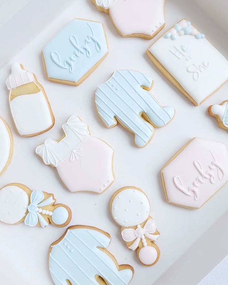 decorated cookies in the shape of baby's names and other items on a white tray