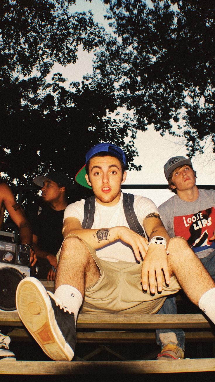 three young men sitting on a bench next to an old radio and boomboxes