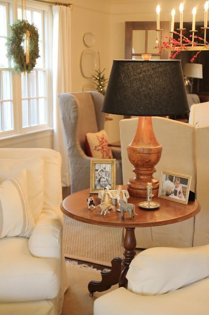 a living room filled with furniture and a lamp on top of a small wooden table