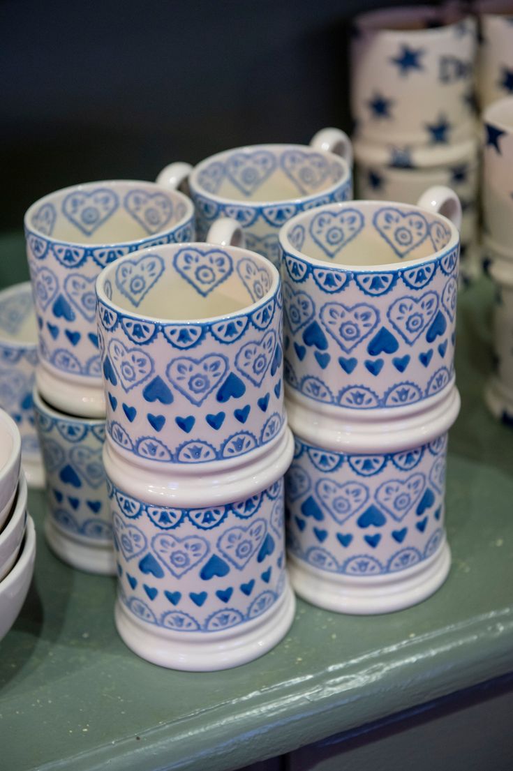 blue and white cups are stacked on top of each other, with hearts in the middle