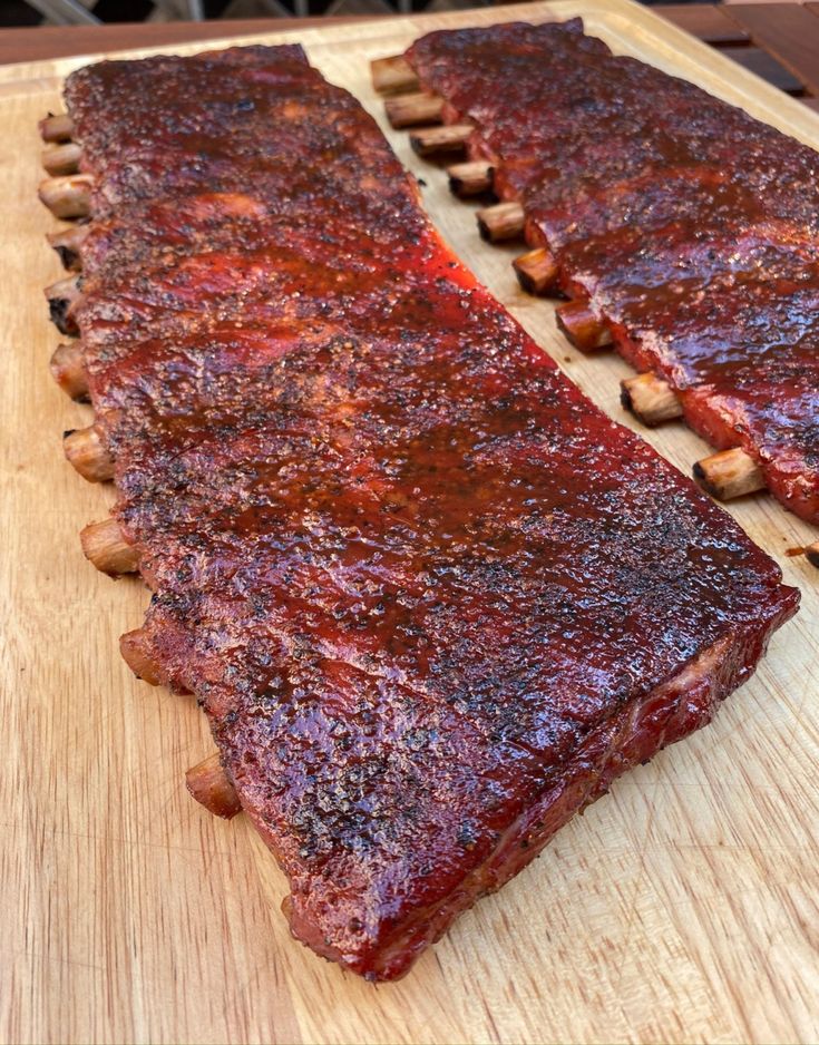 two ribs are sitting on a cutting board