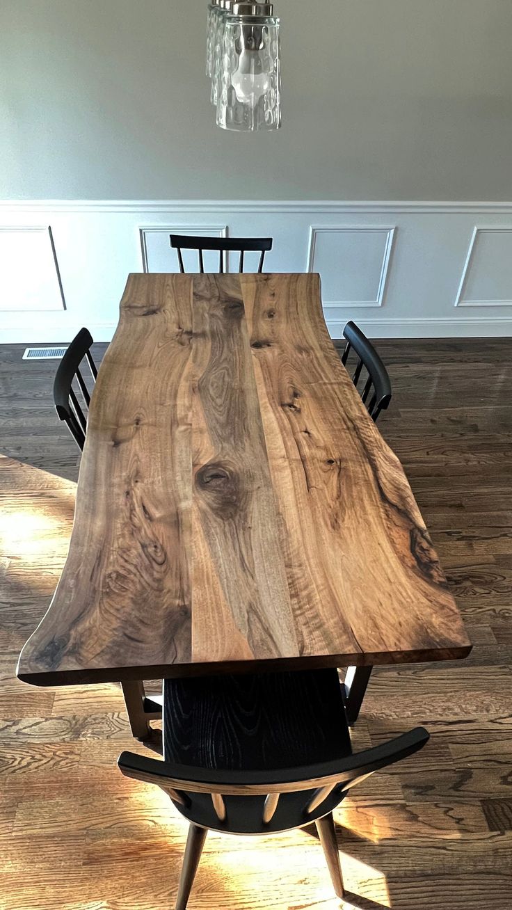 a wooden table with chairs around it on top of a hard wood floored floor