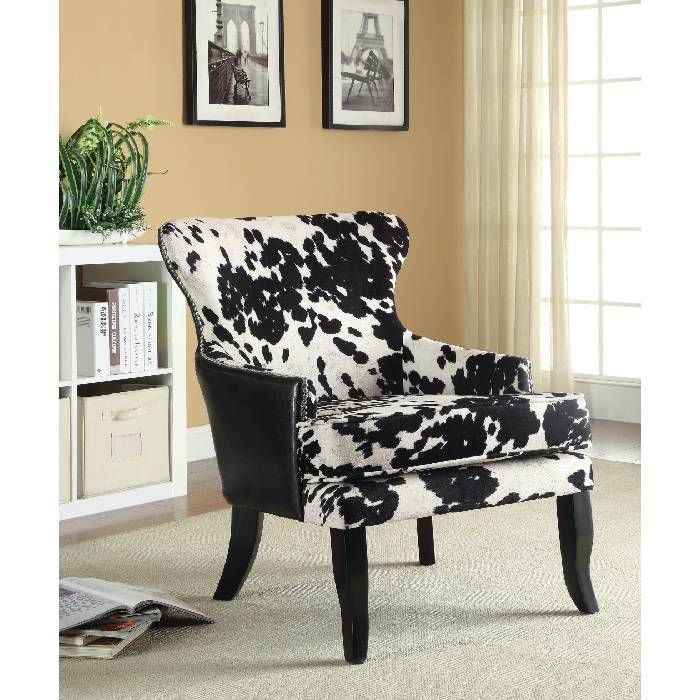 a black and white chair sitting on top of a carpeted floor next to a book shelf