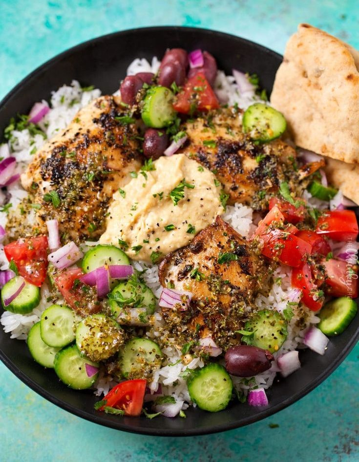 a black bowl filled with rice and vegetables