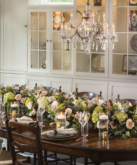 a dining room table is set with flowers and candles for an elegant dinnereon party