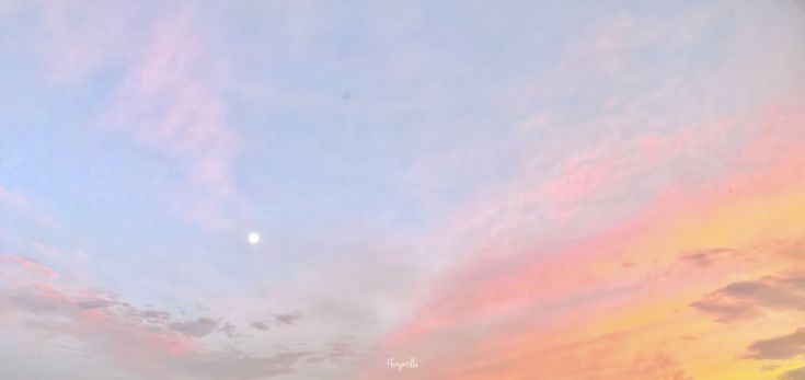 the sky is pink and blue as the sun sets in the distance behind some buildings