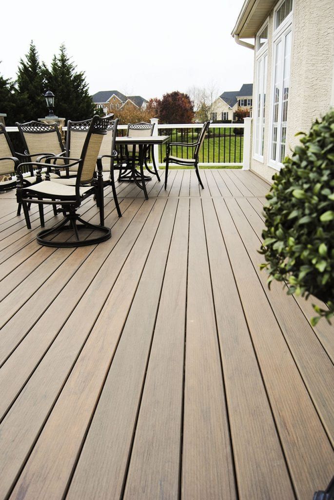 a wooden deck with chairs and table on it