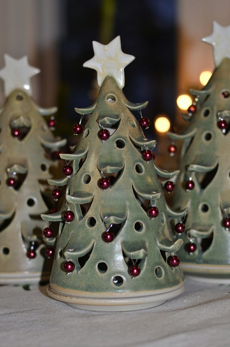 three ceramic christmas trees on a table