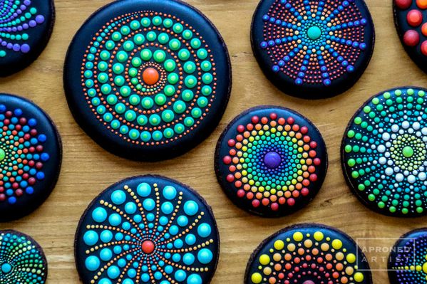 painted rocks are arranged on a wooden surface