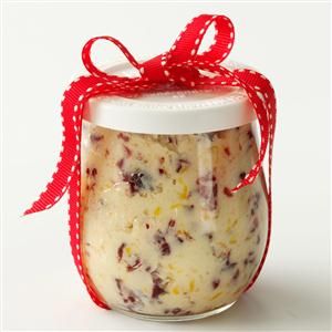 a jar filled with food sitting on top of a white table next to a red ribbon