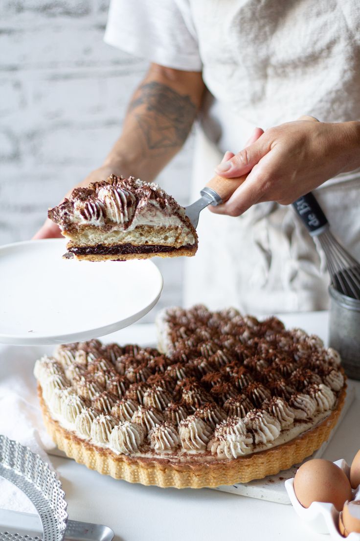 a person holding a piece of cake in front of an egg on a plate next to some eggs