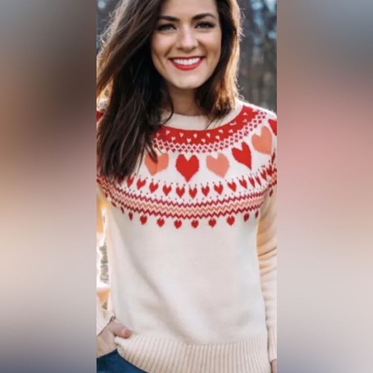 a woman wearing a sweater with hearts on it