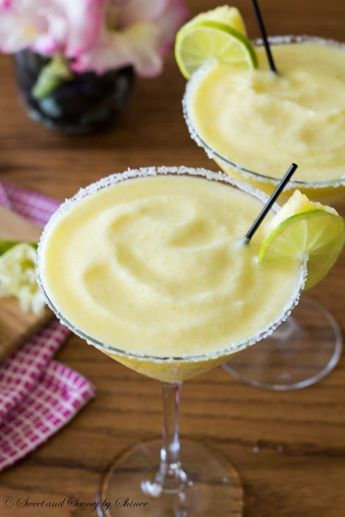 two margaritas sitting on top of a wooden table