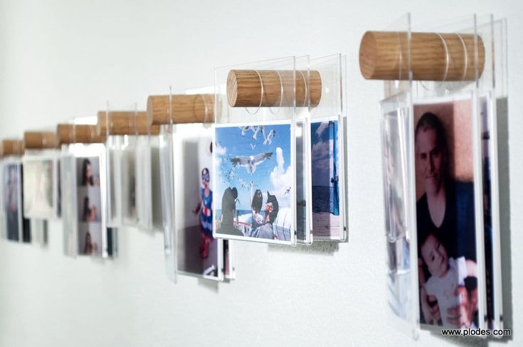 several pictures hanging on a wall with wooden slats attached to the pegs in front of them