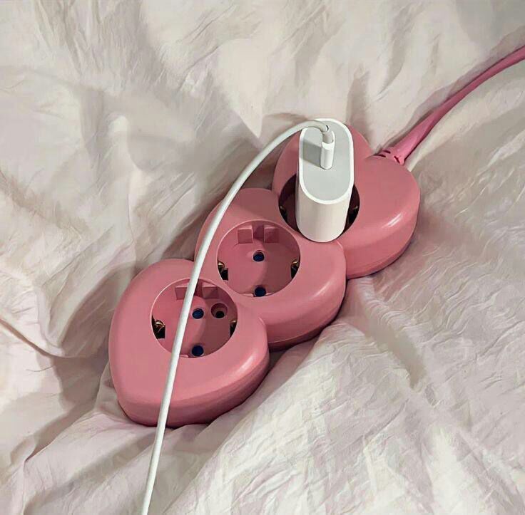 three pink electrical outlets are plugged into the wall