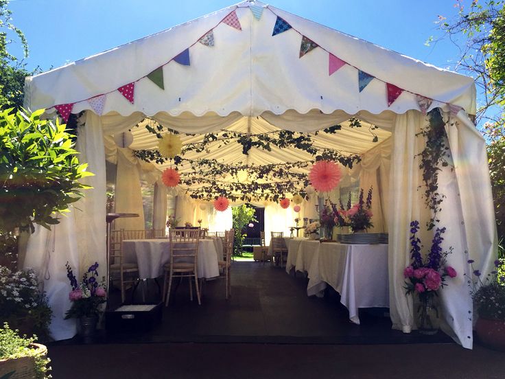 a white tent with tables and chairs under it