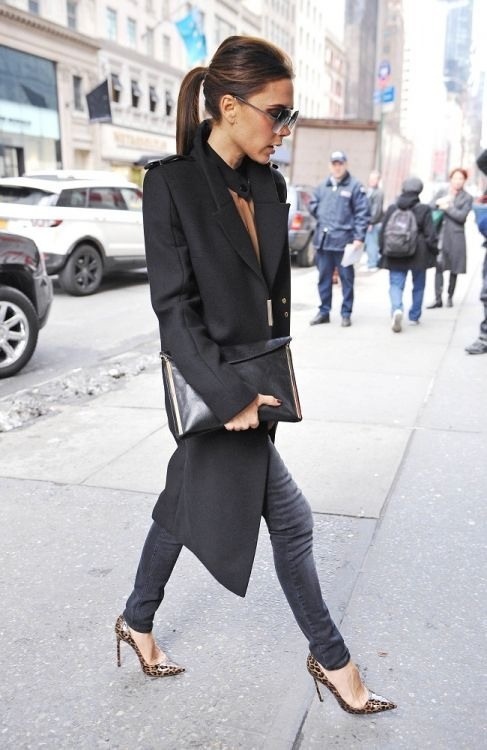 a woman walking down the street in high heels and a black blazer with long sleeves